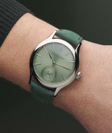 Close-up on a white man's wrist wearing the LF "Série Atelier IV" online exclusive "Classic Micro-Rotor Magnetic Green" with forest green brushed leather bracelet. Shot by Cyril Biselx